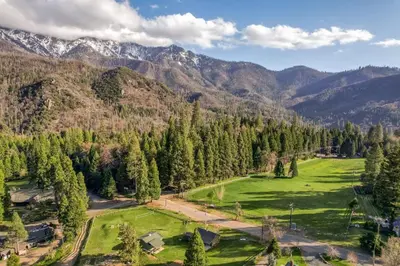 an aerial view of a green field in the mountains at Camp Nelson Lodge Room 2 in Ponderosa