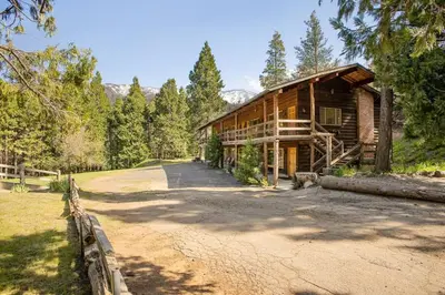 a log cabin with a road in front of it at Camp Nelson Lodge Room 6 in Ponderosa
