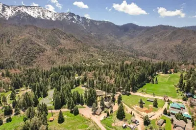 an aerial view of a resort with mountains in the background at Camp Nelson Lodge Room 6 in Ponderosa