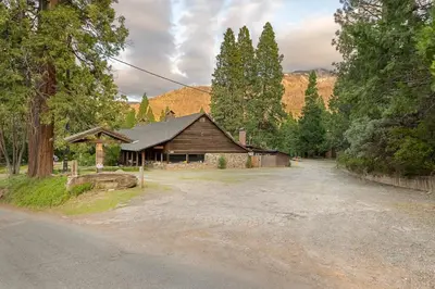 a house in the middle of a dirt road at Camp Nelson Lodge Room 10 in Ponderosa