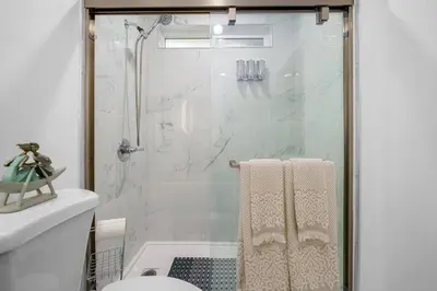 a bathroom with a shower and a toilet with towels at Casa Lanzit - 35 Percent Off All March! in Los Angeles
