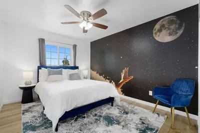 a bedroom with a bed and a mural of the moon at Casa Lanzit - 35 Percent Off All March! in Los Angeles