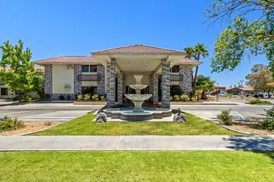 a house with a fountain in the front of it at Red Roof Inn Ridgecrest in Ridgecrest