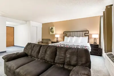 a hotel room with a bed and a couch at Red Roof Inn Ridgecrest in Ridgecrest