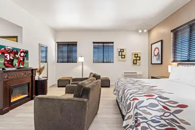 a bedroom with a bed and a couch and a fireplace at Red Roof Inn Ridgecrest in Ridgecrest