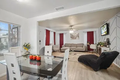 a dining room and living room with a glass table and chairs at Cozy single story 2 bdrm family home near the BLVD in Lancaster