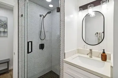 a bathroom with a shower with a sink and a mirror at Modern City Ranch 3 bdrm Family Home Access by Dirt Road in Palmdale