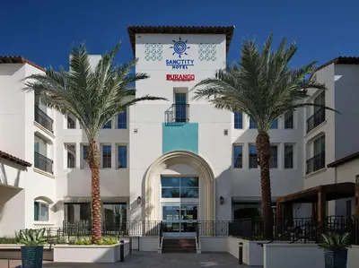 a building with palm trees in front of it at Sanctity Hotel Rancho Cucamonga, Tapestry Collection Hilton in Rancho Cucamonga