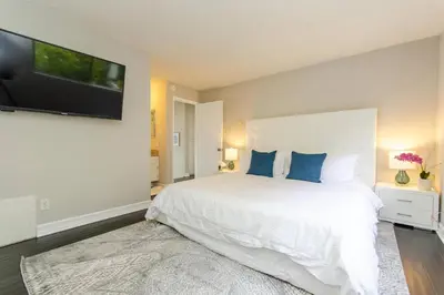 a bedroom with a white bed and a flat screen tv at SURF-N-SAND 2-Bedrooms, MALIBU in Malibu