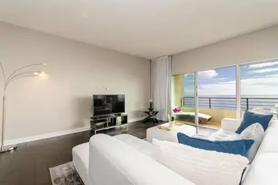 a living room with a white couch and a television at SURF-N-SAND 2-Bedrooms, MALIBU in Malibu