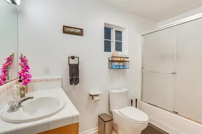a white bathroom with a toilet and a sink at Crestline Home with Deck Less Than 2 Mi to Lake Gregory! in Crestline