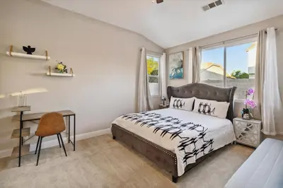 a bedroom with a bed and a desk and a window at Modern 4BR Oasis, Fireplace, Patio & Spacious Family Room in Palmdale