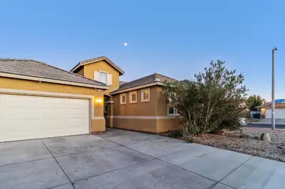 a house with a driveway and a garage at Modern 4BR Oasis, Fireplace, Patio & Spacious Family Room in Palmdale
