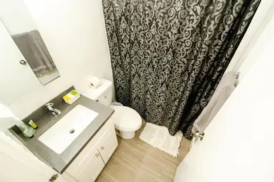 a bathroom with a sink and a toilet and a shower curtain at Cozy 2 Bedroom 1 Bathroom Apartment Ideal for Small Group in Koreatown Free Gated Parking Full Kitch in Los Angeles