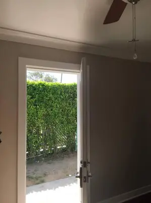 an open door with a window and a hedge at Bedroom Suite with Private Entrance in Los Angeles