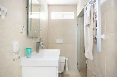 a white bathroom with a sink and a mirror at Bedroom Suite with Private Entrance in Los Angeles