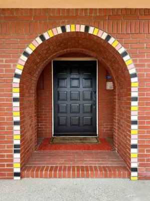 a black door in a brick building with an archway at Cool Cali Vibe - Barefoot Stepping Distance 2 Sand in Oxnard