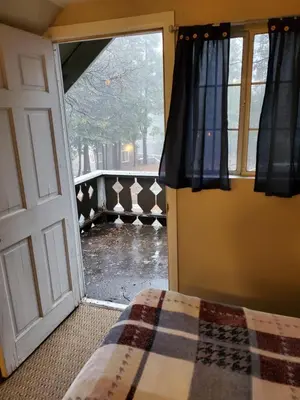 a bedroom with a door open to a yard at The Treetop Terrace at The Historic Arrowhead Lodge in Twin Peaks
