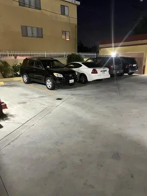 three cars parked in a parking lot at night at King Motel in Los Angeles