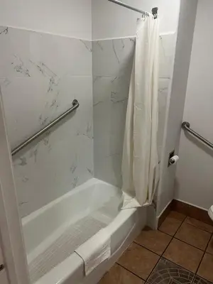 a bathroom with a shower with a white tub at King Motel in Los Angeles