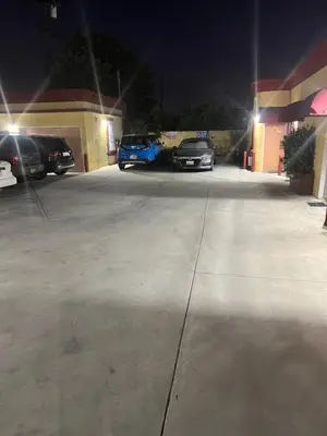 two cars parked in a parking lot at night at King Motel in Los Angeles