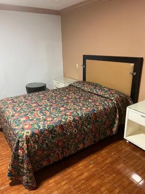 a bedroom with a bed with a colorful bedspread at King Motel in Los Angeles