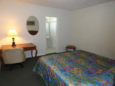 a bedroom with a bed and a desk and a table and chair at Travel Inn in North Hills