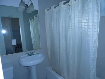 a bathroom with a sink and a shower curtain at Travel Inn in North Hills