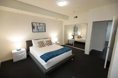 a bedroom with a large bed and a mirror at Downtown Cosmopolitan Residences in Los Angeles