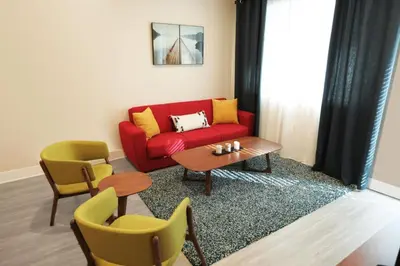 a living room with a red couch and chairs at Downtown Cosmopolitan Residences in Los Angeles