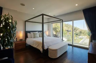 a bedroom with a canopy bed and a large window at Luxe in Hollywood Hills- modern oasis, pool 5 min to Sunset in Los Angeles