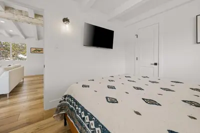 a bedroom with a bed and a tv on a wall at Luxe Lakefront with Hot Tub, Fire Pit, Game Room, Boat Dock in Big Bear Lake