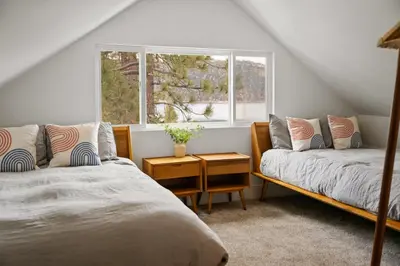 a bedroom with two beds and a window at Luxe Lakefront with Hot Tub, Fire Pit, Game Room, Boat Dock in Big Bear Lake