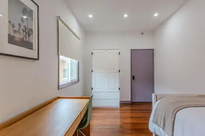 a bedroom with a bed and a wooden floor at Westholme Park - Female Only in Los Angeles