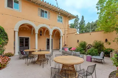 a patio with tables and chairs in front of a building at Westholme Park - Female Only in Los Angeles