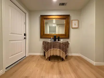 a room with a table with a mirror and a door at Pasadena Old Town Cottage in Pasadena