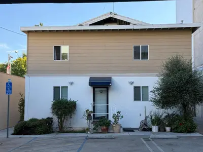 a white house with a blue awning at Pasadena Old Town Cottage in Pasadena