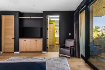 a bedroom with black walls and a tv and a chair at The Bella Villa Venice Beach - luxury interior design - spa and terrace in Los Angeles
