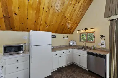 a kitchen with a white refrigerator and a sink at Lake Arrowhead Charming Chalet in Lake Arrowhead