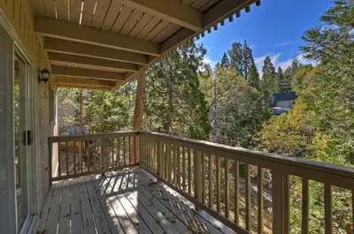 a porch with a view of the woods at Lake Arrowhead Charming Chalet in Lake Arrowhead