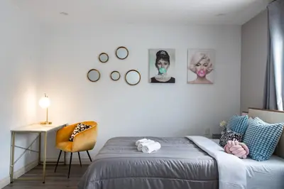 a bedroom with a bed and a desk and pictures on the wall at Luxury Oasis in Culver City! Free parking and Jacuzzi in Los Angeles
