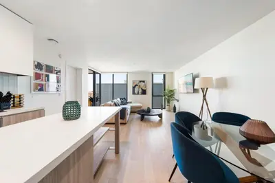 a living room with a counter and blue chairs at The Sapphire Nest - Spectacular Rooftop Amenities Ocean views 2BR in Los Angeles