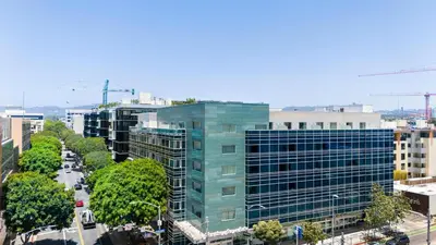 a tall glass building on a city street at The Sapphire Nest - Spectacular Rooftop Amenities Ocean views 2BR in Los Angeles