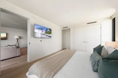 a white bedroom with a large bed and a couch at The Sapphire Nest - Spectacular Rooftop Amenities Ocean views 2BR in Los Angeles