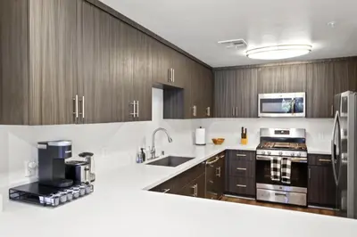 a kitchen with white counter tops and wooden cabinets at 4bd Townhouse - Special Limited Time Offer near Venice Beach! in Los Angeles