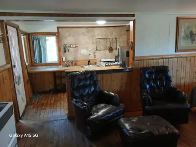 a room with two chairs and a kitchen with a sink at Big Bear Lake - Tulip Lane Cabin #21 in Big Bear Lake