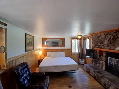 a hotel room with a bed and a fireplace at Big Bear Lake - Tulip Lane Cabin #21 in Big Bear Lake