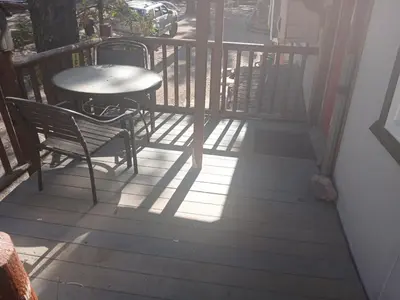a patio with a table and chairs on a balcony at Big Bear Lake - Tulip Lane Cabin #22 in Big Bear Lake