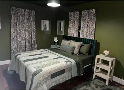 a green bedroom with a bed and a stool at Cozy and Spacious Duplex in Los Angeles