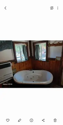 a bath tub in a room with two windows at Big Bear Lake - Tulip Lane Cabin #24 in Big Bear Lake
